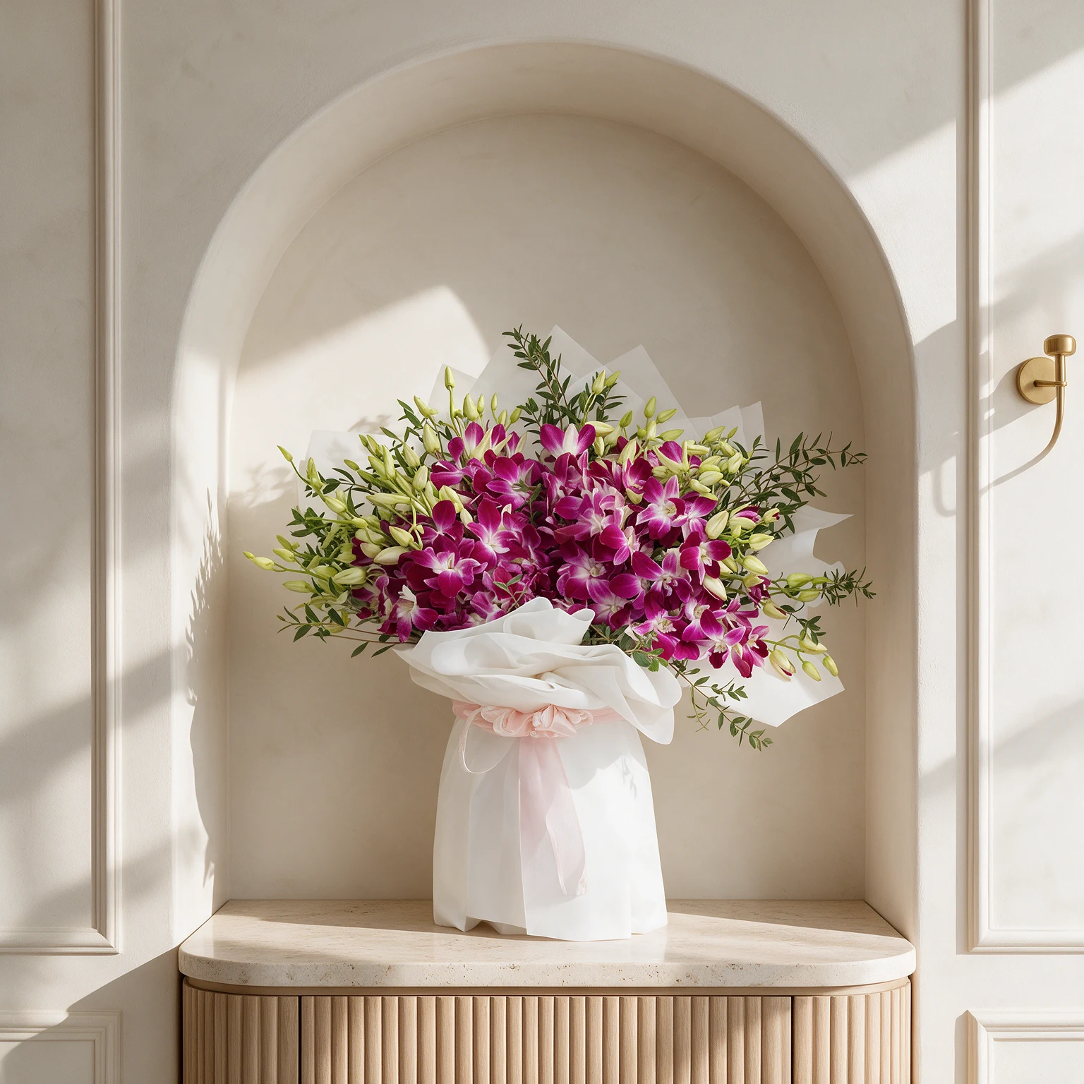 Magenta orchids with white centres and fresh green foliage, arranged in elegant white wrapping with a pale pink ribbon.